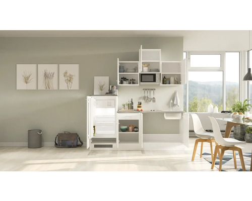 Kompaktná kuchyňa s chladničkou, drezom, mikrovlnnou rúrou a úložným priestorom v svetlej miestnosti.