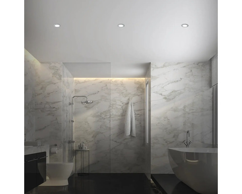 Svetlá kúpeľňa so sprchou, vaňou, toaletou a mramorovými obkladmi.