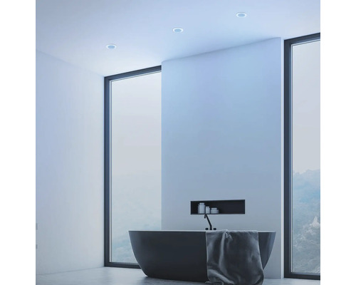 Moderná kúpeľňa s voľne stojacou vaňou, uterákom a stropnými bodovými svietidlami.