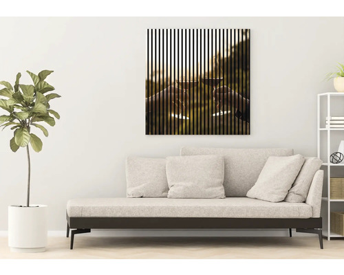 Obývacia izba s pohovkou a zarámovaným obrazom s vertikálnymi pruhmi zobrazujúcimi dva štrngajúce poháre na víno.