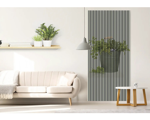 Obývacia izba s pohovkou, stolom a nástennou dekoráciou s motívom rastlín za čiernymi pruhmi