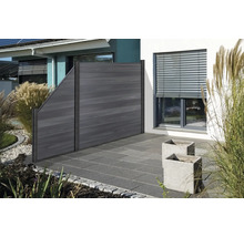 Drevený plot v záhradnej oblasti s rastlinami a dlažobnými kockami