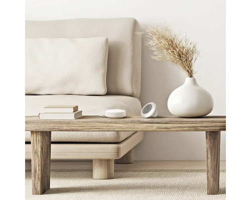 Obývacia izba s pohovkou, stolom, vázou, vlhkomerom a teplomerom