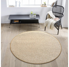 Béžový okrúhly koberec v obývacej izbe s kreslom a stolom