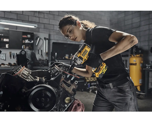 Žena používa akumulátorový rázový uťahovák DeWalt na motore automobilu v dielni