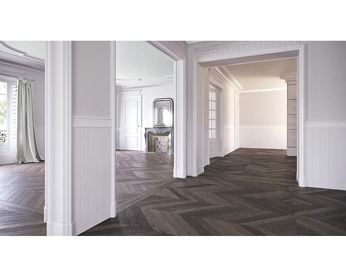 Svetlá miestnosť s parketami do rybej kosti, bielymi stenami a štukovými ozdobami