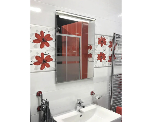 Svetlá kúpeľňa s umývadlom, osvetlenou zrkadlovou skrinkou a kvetinovými obkladmi