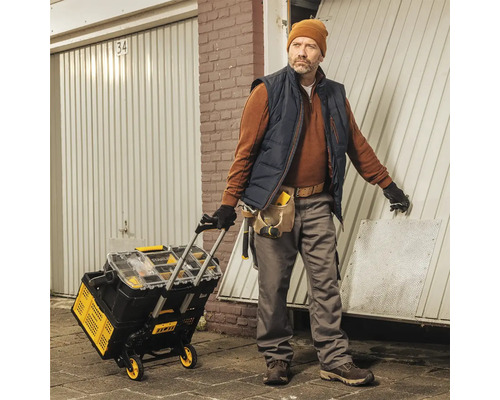 Remeselník s vozíkom na náradie pred garážou