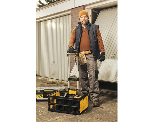 Remeselník pred garážami s debnou na náradie a náradím