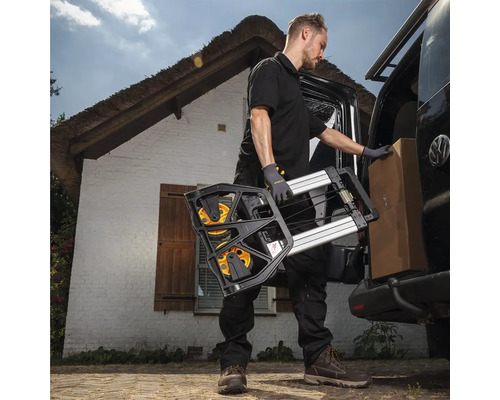 Muž vykladá rudlu a škatuľu z dodávky pred domom