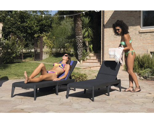 Dve ženy relaxujú na lehátkach v záhrade.