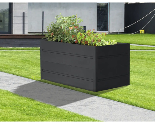 Obdĺžnikový kovový kvetináč s rastlinami v záhrade.