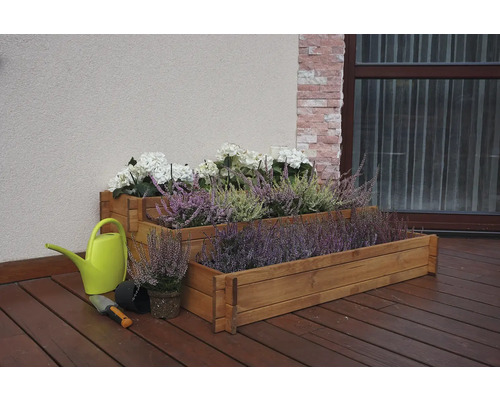 Drevený kvetináč s vresom a hortenziami, kanva a záhradná lopatka na terase