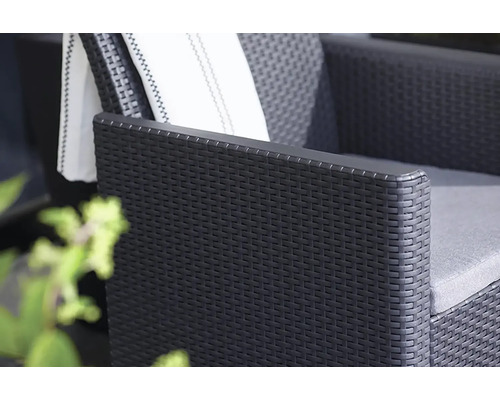 Detailný pohľad na čierne ratanové kreslo s vankúšmi