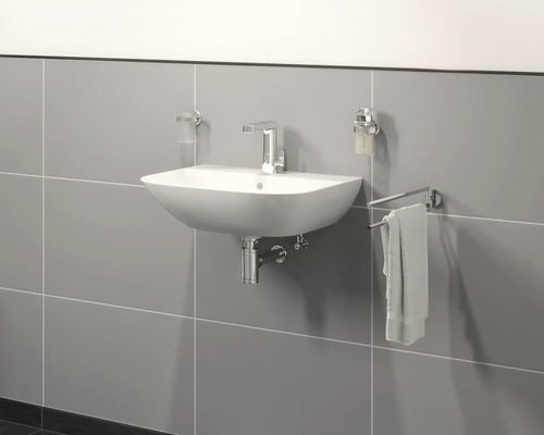 Umývadlo s batériou, dávkovačom mydla, pohárom na zubné kefky a držiakom na uteráky na sivej stene