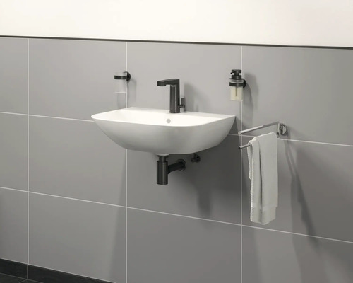 Nástenné umývadlo s vodovodnou batériou, dávkovačom mydla, pohárom na zubné kefky a držiakom na uteráky v kúpeľni.