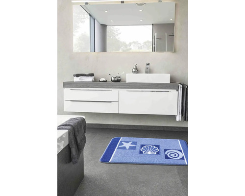 Kúpeľňa s umývadlom, zrkadlom a modrou kúpeľňovou predložkou s námorníckymi motívmi