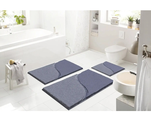 Kúpeľňa s vaňou, toaletou, umývadlom a súpravou troch kúpeľňových predložiek rôznych veľkostí a dvojfarebného dizajnu