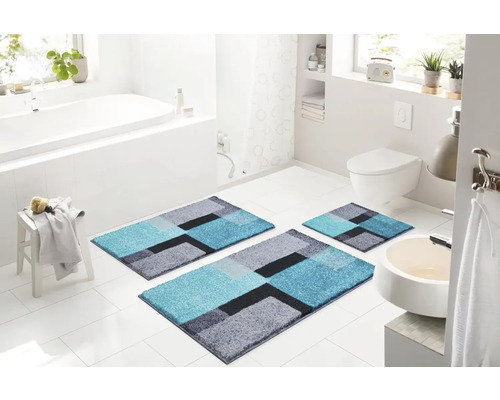 Kúpeľňa s vaňou, toaletou a umývadlom a súpravou kúpeľňových predložiek s geometrickým vzorom pozostávajúcou z troch kusov