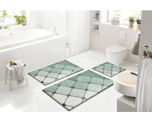 Kúpeľňa s vaňou, umývadlom, toaletou a súpravou troch kúpeľňových predložiek s geometrickým vzorom