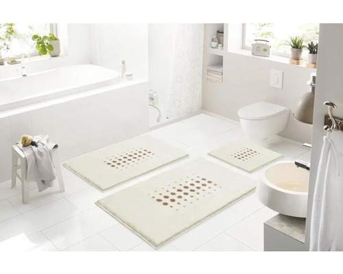 Svetlá kúpeľňa s vaňou, umývadlom, toaletou a súpravou troch kúpeľňových koberčekov s bodkovaným vzorom