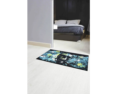 Izba s posteľou a rohožkou s motívom lebky