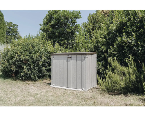 Plastová záhradná skrinka vonku pred zelenými rastlinami