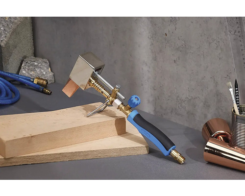 Strešný horák s hadicou a drevom na sivom pozadí