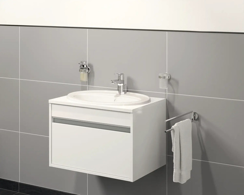 Moderná kúpeľňa s bielou skrinkou pod umývadlo, umývadlom, dávkovačom mydla, pohárom na zubné kefky a držiakom na uteráky