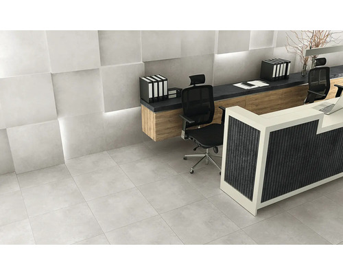 Scéna so svetlosivou dlažbou, recepciou a kancelárskym nábytkom.