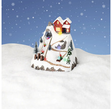 Dekoratívna zimná krajina s horskou chatou a sánkarmi