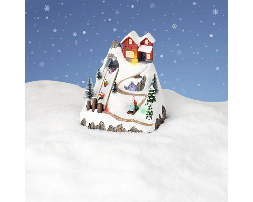 Dekoratívna zimná krajina s horskou chatou a sánkarmi