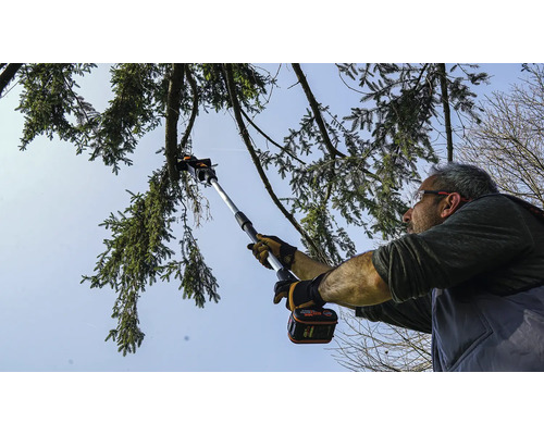 Muž strihá konáre stromov pomocou akumulátorovej prerezávacej píly