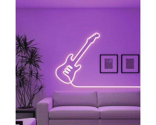 Dekoratívne neónové svetlo v tvare gitary na stene nad pohovkou