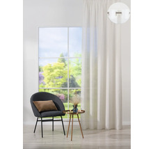 Obývacia izba so závesom, stoličkou a odkladacím stolíkom pred oknom