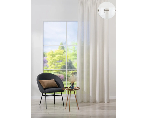 Obývacia izba so závesom, stoličkou a odkladacím stolíkom pred oknom