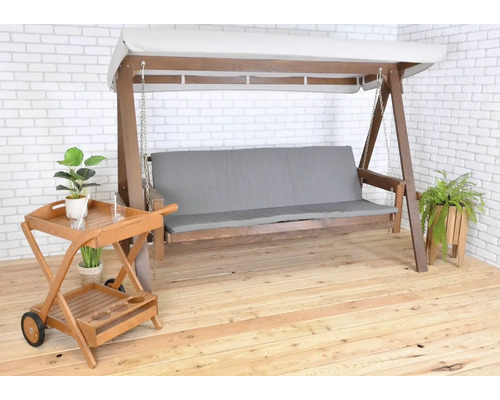 Drevená hojdačka so svetlosivým vankúšom a servírovacím vozíkom na terase