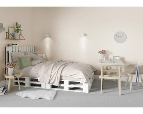 Spálňa s posteľou z drevených paliet, písacím stolom a stoličkou