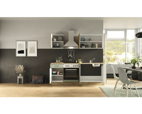 Kuchyňa s umývadlom, sporákom, digestorom a závesnými skrinkami vo svetlej izbe.