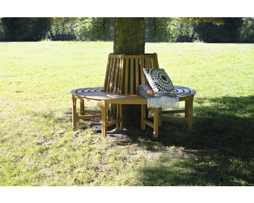 Drevená lavička okolo stromu s vankúšom a dekou v záhrade