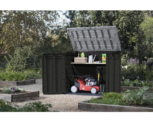 Otvorená záhradná skriňa so záhradným náradím v záhrade