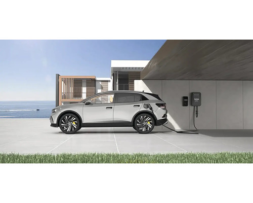 Elektromobil sa nabíja pri nabíjacej stanici pred moderným domom