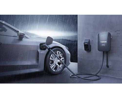 Elektroauto pri nabíjacej stanici s logom Topdon v daždi