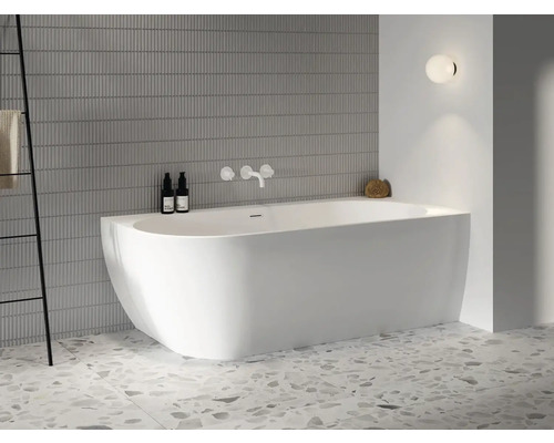 Svetlá kúpeľňa s voľne stojacou vaňou, armatúrami, držiakom na uteráky a nástennou lampou