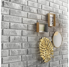 Nástenná dekorácia s kamenným vzhľadom a dekoratívnymi prvkami, ako sú rámčeky na fotografie, zrkadlo a listová ozdoba