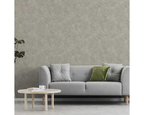 Obývacia izba s pohovkou, vankúšmi a konferenčným stolíkom pred tapetou