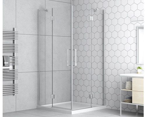 Rohová sprcha s čírymi sklenenými dverami a rebríkovým radiátorom na uteráky v kúpeľni s dlaždicami