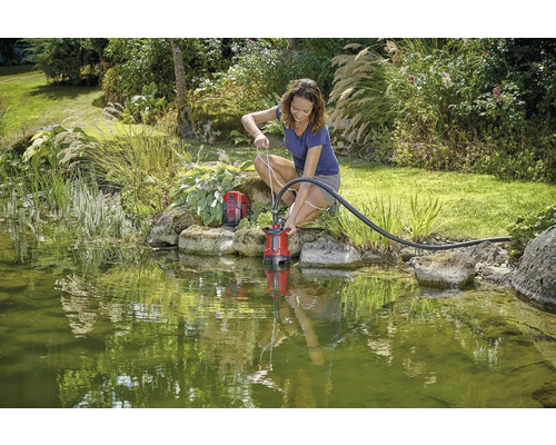 Žena používa jazierkové čerpadlo v záhradnom jazierku