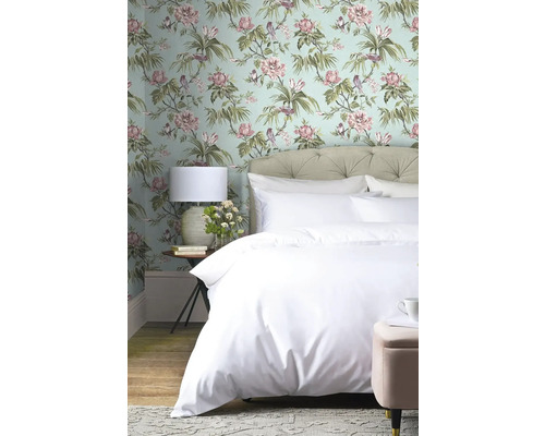 Spálňa s kvetinovou tapetou, posteľou a nočnou lampou