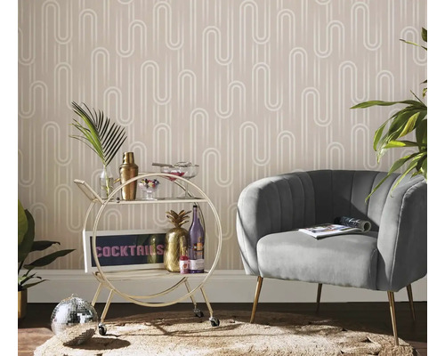 Obývacia izba s kreslom, servírovacím vozíkom a vzorovanou tapetou